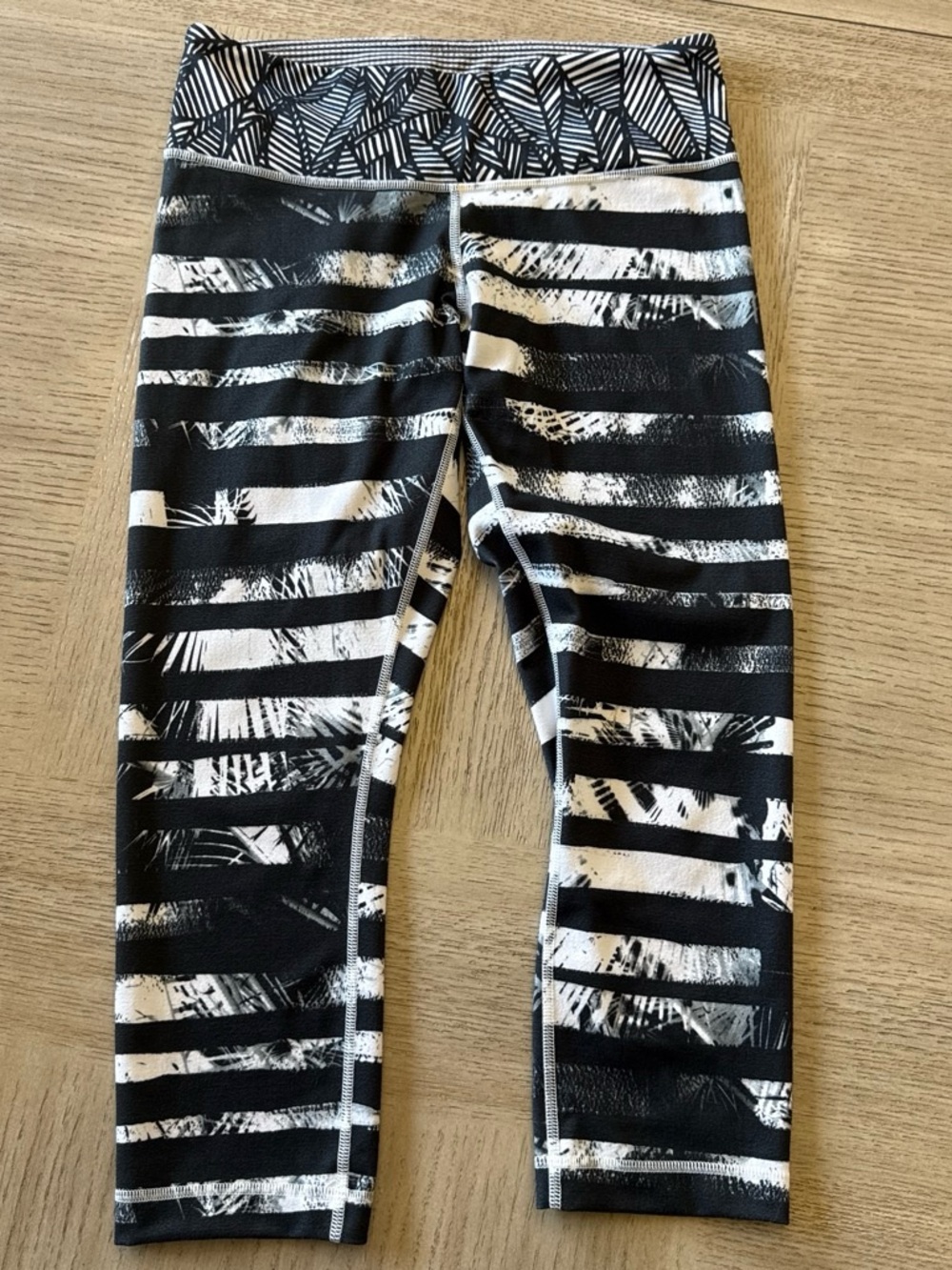 Women’s Lululemon White & Black striped and leaf pattern capri legging. Size 8
